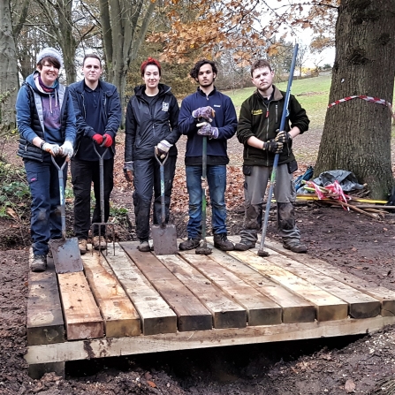 Natural Prospects trainees with the bridge they have built at Licky Hills