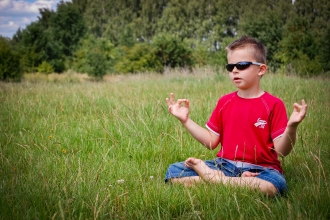 Child meditating in field