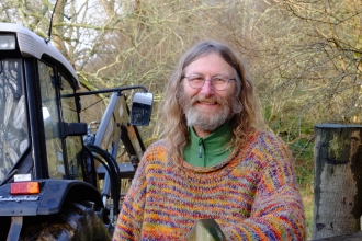 Rob standing next to a tractor holding wire