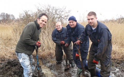 A group of friends dig in the mud