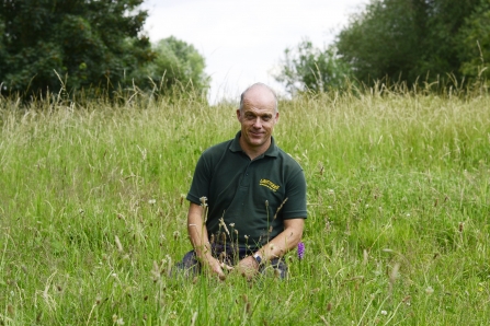 man sitting in field wildlife trust